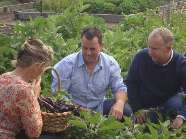 Nicky gathers up a basket of fresh vegetables with Tony Howell and Patrick Coward.