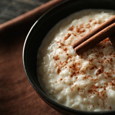 Delicious rice pudding with cinnamon in bowl, closeup